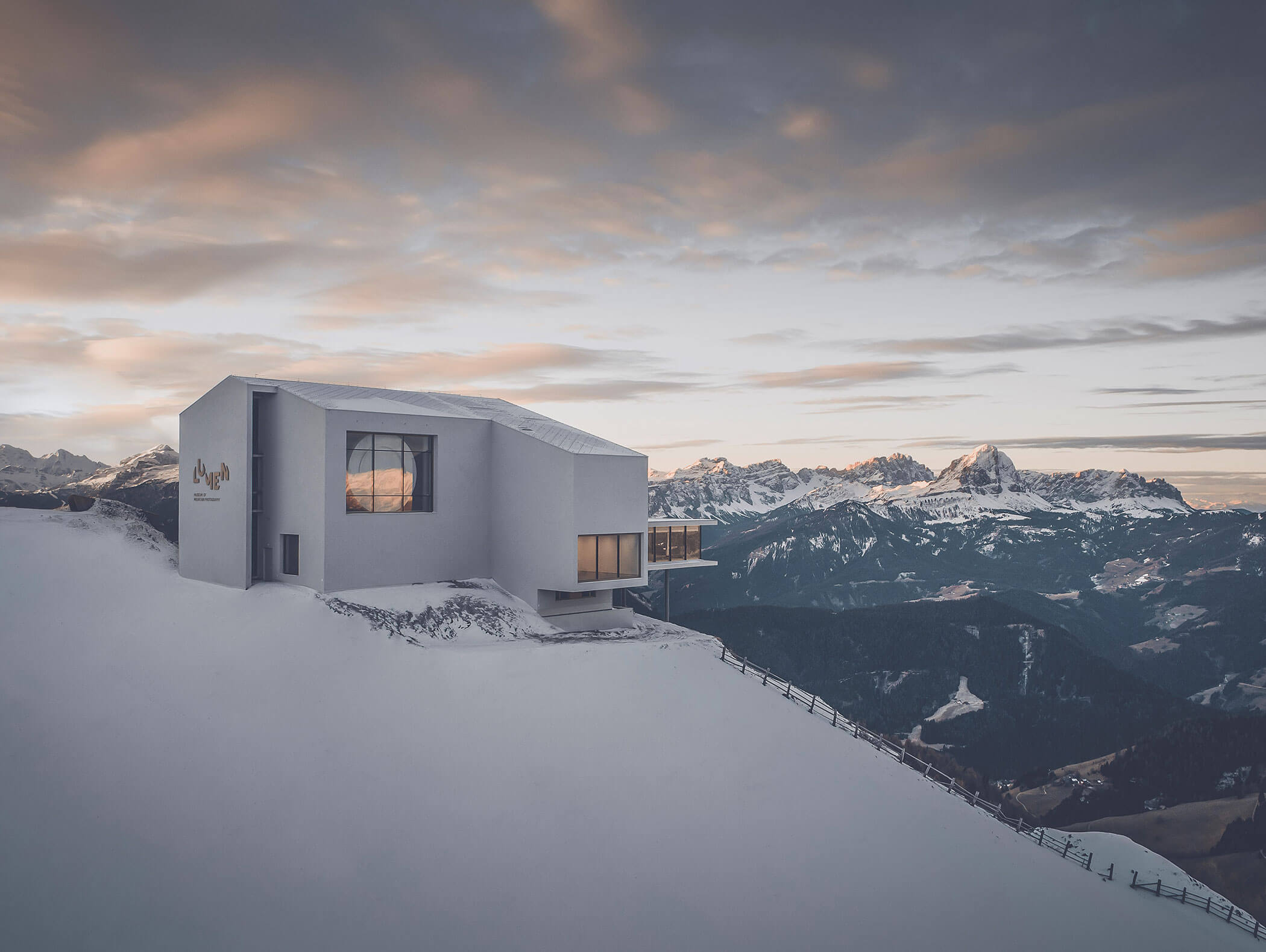 Modernes Gebäude auf einem verschneiten Berghang mit malerischer Bergkette und bewölktem Himmel im Hintergrund. - Hotel B&B MyLiving
