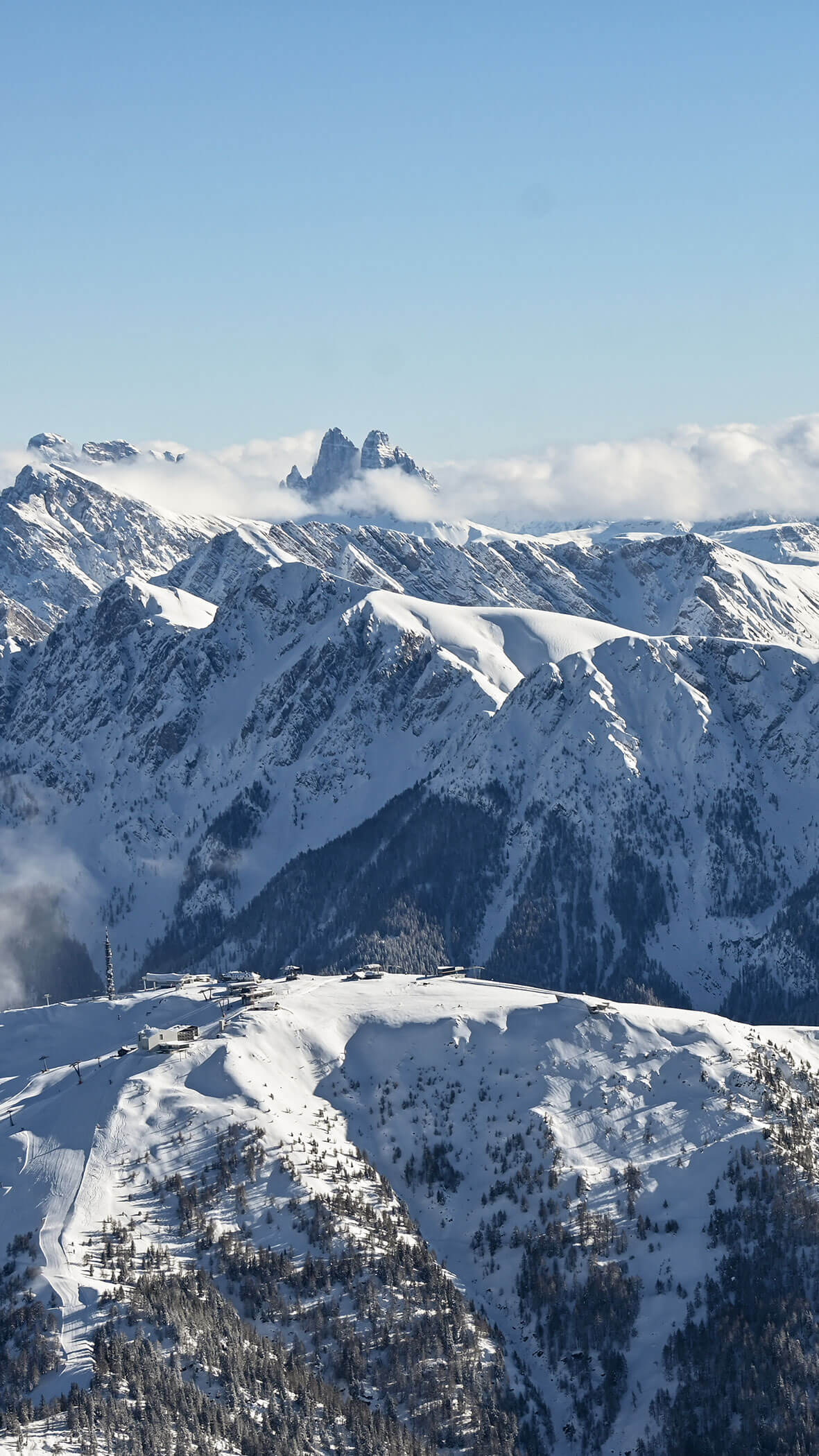 Eine schneebedeckte Gebirgskette unter einem klaren blauen Himmel mit Wolken, die zwischen den Gipfeln dahinziehen. - Hotel B&B MyLiving