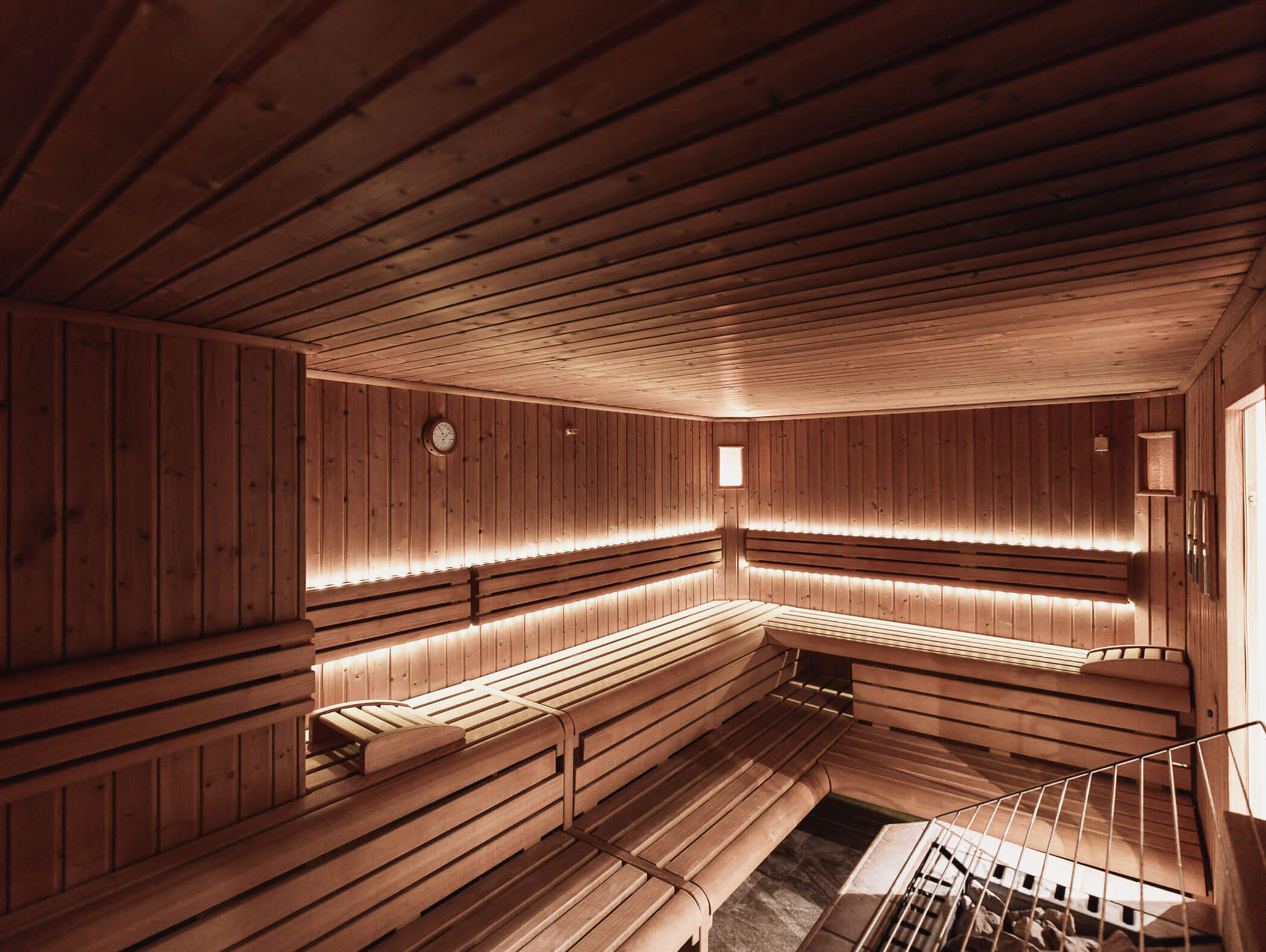 Holzgetäfelter Saunaraum mit Bänken, sanfter Beleuchtung und einem Ofen in der Ecke. - Hotel B&B MyLiving