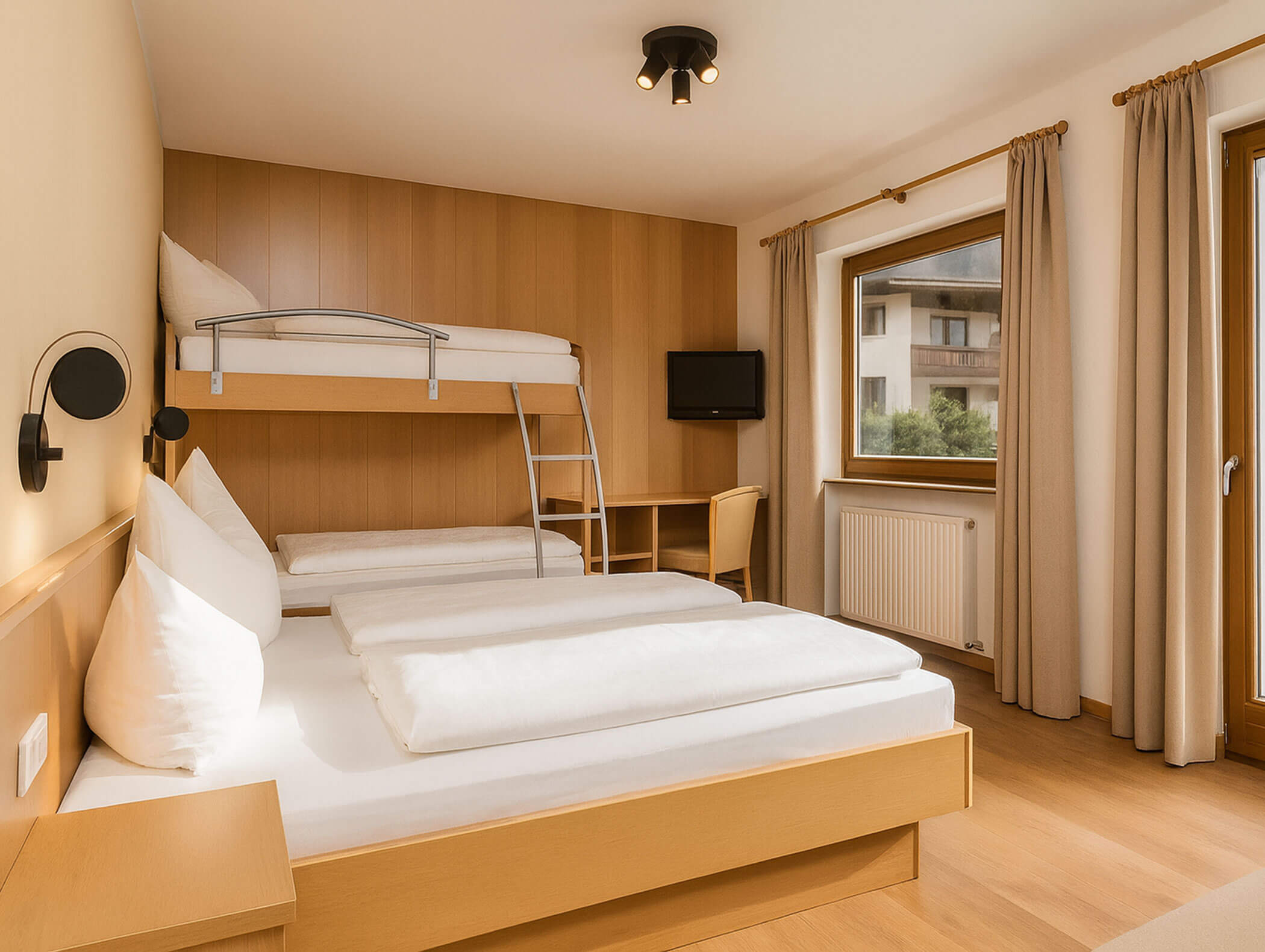 Helles Hotelzimmer mit Doppelbett, Etagenbett, Schreibtisch, TV und großen Fenstern mit beigen Vorhängen. - Hotel B&B MyLiving